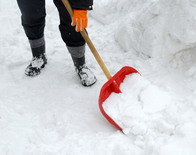 Pet sitter shoveling snow pet sitter wear gloves and boots shoveling snow at a client's home